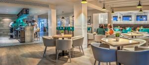 a restaurant with tables and chairs and people in the background at HG Lomo Blanco in Puerto del Carmen