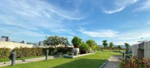 a park with green grass and bushes and a blue sky at No 498 SPD in Phuket Town