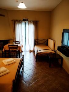 a room with two beds and a tv and a couch at Guesthouse Eleftherios in Kalavrita