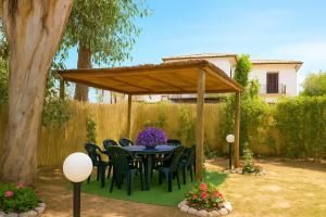 patio con tavolo e sedie sotto un baldacchino di Villa Carla accesso al mare privato posto auto riservato a Sperlonga