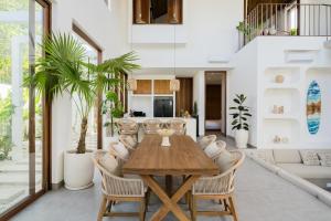 ein Esszimmer mit einem Holztisch und Stühlen in der Unterkunft Villa Utopia Uluwatu in Uluwatu