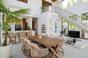 ein Esszimmer mit einem Holztisch und Stühlen in der Unterkunft Villa Utopia Uluwatu in Uluwatu