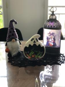 Una mesa con una bruja de juguete y una jaula de pájaros. en The Place To Be - à 5 min de Disneyland Paris, en Serris