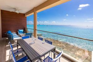 SeaDreams 4 في West Bay: شرفة مع طاولة وكراسي والمحيط