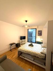 Un dormitorio con una cama y un escritorio y una ventana. en Studio Boileau Tour Eiffel, en París