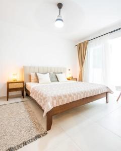 ein weißes Schlafzimmer mit einem großen Bett und einem Fenster in der Unterkunft Hydra 103 Poolview Luxury Apt Dominicus in La Laguna