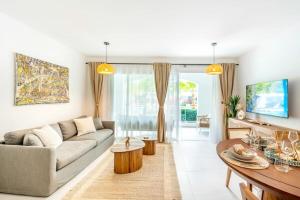 ein Wohnzimmer mit Sofa und Tisch in der Unterkunft Hydra 103 Poolview Luxury Apt Dominicus in La Laguna
