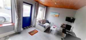 a living room with a couch and a window at Blue Door Apartment Main St, Carrigart, F92HC04 in Carrigart