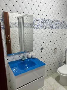 a bathroom with a blue sink and a toilet at CasaTanha in Mindelo