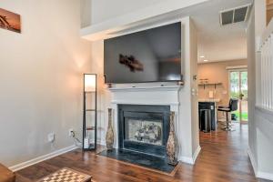 Una sala de estar con chimenea y un televisor encima. en Chic Charlotte Townhome with Community Pool, en Charlotte