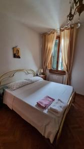 a bedroom with a large white bed with a window at Casa ALDA in Molino del Piano
