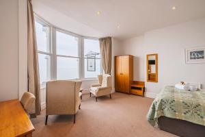 a bedroom with a bed and a desk and a chair at The Glengower in Aberystwyth