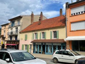 two cars parked on a street in front of buildings at Au cœur de la perle du jura in Champagnole