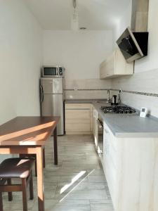 a kitchen with white appliances and a wooden table at Sunny Stay by Grafit in Legnica +5 photos