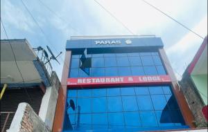 Un edificio con un cartel al costado. en Paras Restaurant and Lodge, en Khairbana