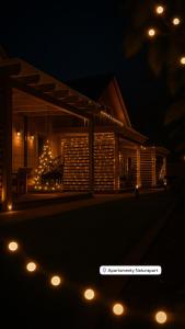 ジブヌフにあるApartamenty Naturapartの夜に椅子とライトのあるデッキ