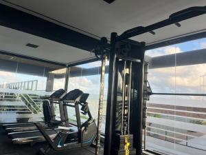 a gym with two treadmills in front of a window at Luxuoso Flat pé na areia no Restinga in João Pessoa