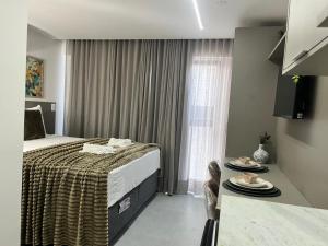 a bedroom with a bed and a table with plates on it at Luxuoso Flat pé na areia no Restinga in João Pessoa +6 photos