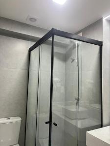 a glass shower in a bathroom with a toilet at Luxuoso Flat pé na areia no Restinga in João Pessoa