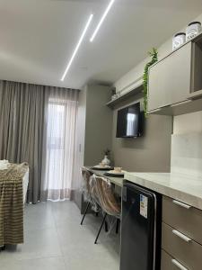 a kitchen with a counter and a table with chairs at Luxuoso Flat pé na areia no Restinga in João Pessoa