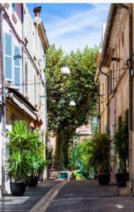 an empty street with potted plants in an alley at Charmant appartement Port & Plages ! in Bandol