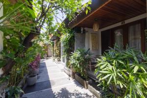 a walkway in front of a house with plants at Wayan Homestay Sanur in Sanur