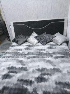 Una cama con tres almohadas encima. en Miledi, en Bălţi 2 fotos más