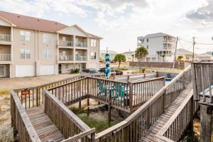 ein Holzsteg, der zum Strand mit einem Spielplatz führt in der Unterkunft Kokomo Key on Navarre Beach - Private Pool in Navarre