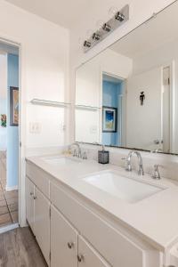 ein Badezimmer mit zwei Waschbecken und einem großen Spiegel in der Unterkunft Kokomo Key on Navarre Beach - Private Pool in Navarre