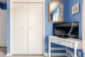 ein Schlafzimmer mit einem weißen Schreibtisch und einem Spiegel in der Unterkunft Kokomo Key on Navarre Beach - Private Pool in Navarre