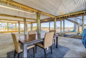 ein Esszimmer mit Tisch und Stühlen und einer Hängematte in der Unterkunft Kokomo Key on Navarre Beach - Private Pool in Navarre