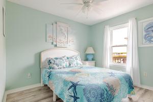 ein Schlafzimmer mit einem Bett mit blauen Wänden und einem Fenster in der Unterkunft Kokomo Key on Navarre Beach - Private Pool in Navarre + 53 Fotos