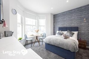 a bedroom with a bed and a table with chairs at Eden Bay Serviced Apartments - Eden in Morecambe