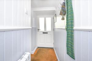ein Flur mit einer weißen Tür und einem Fenster in der Unterkunft Fairview in Lerwick