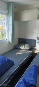 Un dormitorio con dos camas y una ventana. en Mobilhome - La Palmyre Camping, en La Palmyre 19 fotos más