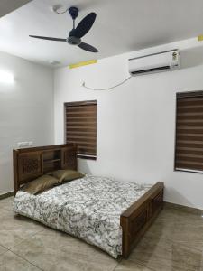 a bedroom with a bed and a ceiling fan at White Shadow in Varkala