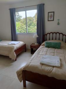 a bedroom with two beds and a window at DOS ALAMOS - CASA - Colinas Verdes in Mar del Plata +55 photos