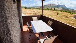 a table and chairs on a balcony with a view at Ruralux Campo San Juan II in Moratalla