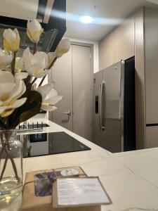 a kitchen with a vase of flowers on a counter at Modern Condo in Núcleo La Sabana with Pool in San José