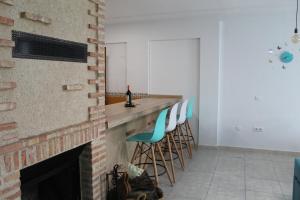 a living room with a brick fireplace and blue stools at Atardecer dorado in Ruidera