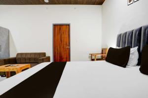 a bedroom with a large bed and a living room at Hotel O Aparna and Marriage Lawn in Balrāmpur