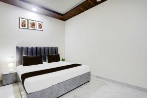 a white bedroom with a large bed in it at Hotel O Aparna and Marriage Lawn in Balrāmpur