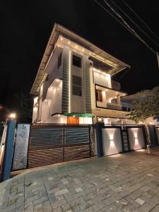 a house with a fence in front of it at night at White Shadow in Varkala
