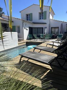 a swimming pool with chairs and a house at Villa La Remoise in Sainte-Marie-de-Ré