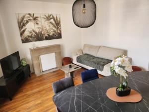 a living room with a table and a couch at T3 Le logis de Martin - city center - near Ducale Place with parking space in Charleville-Mézières