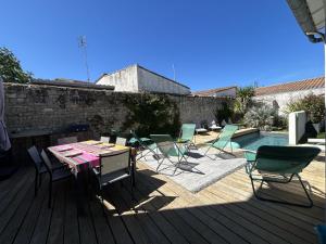 a patio with a table and chairs next to a pool at Villa La Remoise in Sainte-Marie-de-Ré