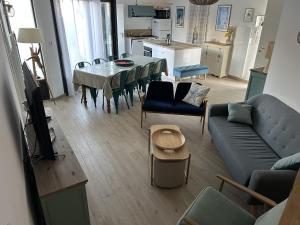 a living room with a couch and a table with chairs at Villa La Remoise in Sainte-Marie-de-Ré +29 photos