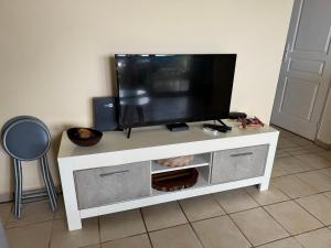 a flat screen tv sitting on top of a white entertainment center at Le SPRITZ - Appartement d'une chambre VUE MER in Marigot