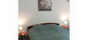 a bedroom with a bed and two tables with candles at Le SPRITZ - Appartement d'une chambre VUE MER in Marigot