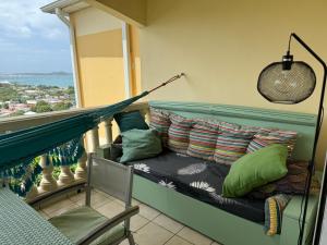 a hammock on a balcony with a view of the ocean at Le SPRITZ - Appartement d'une chambre VUE MER in Marigot
